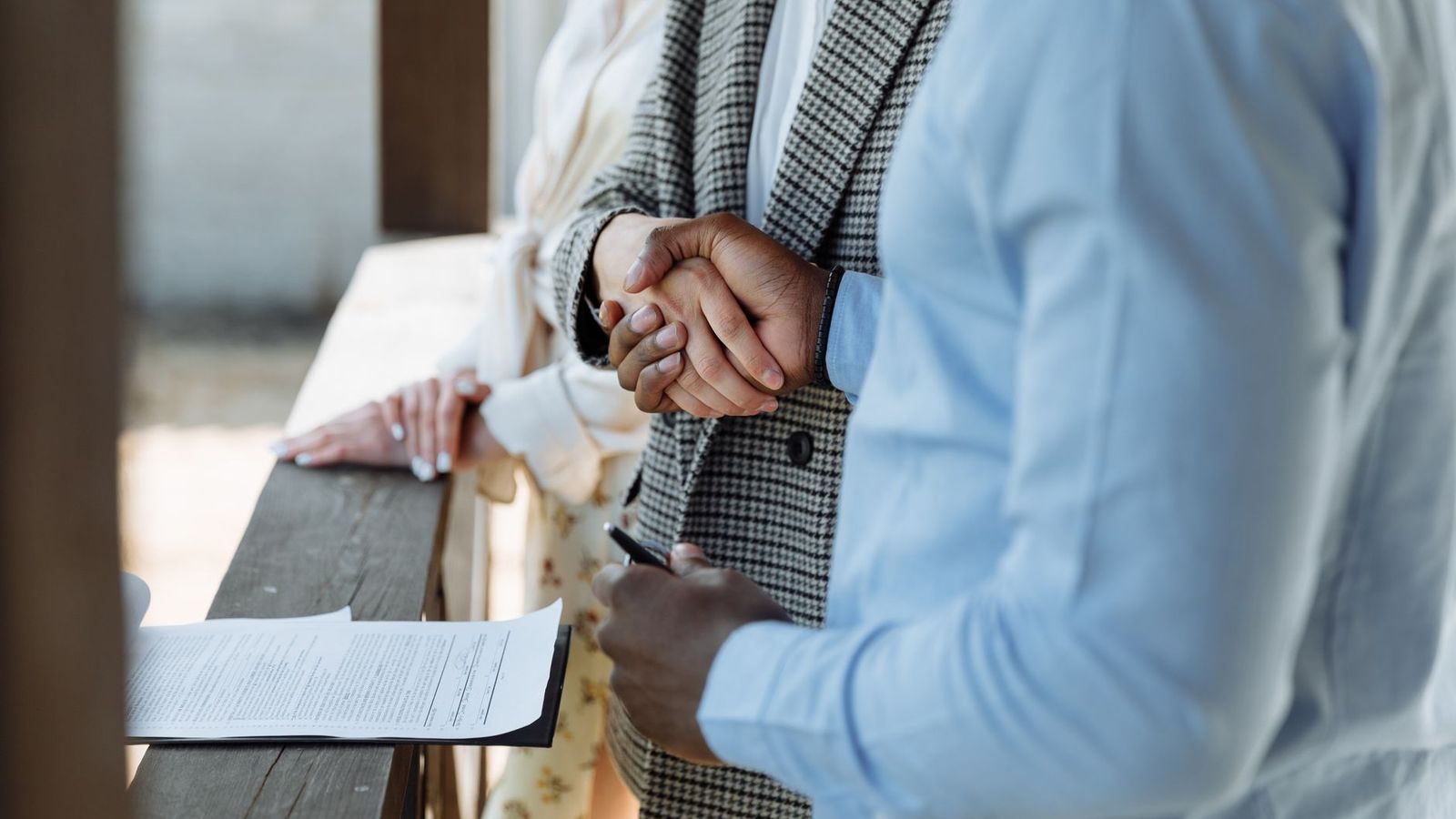 Une poignée de main au-dessus d'un contrat immobilier signé